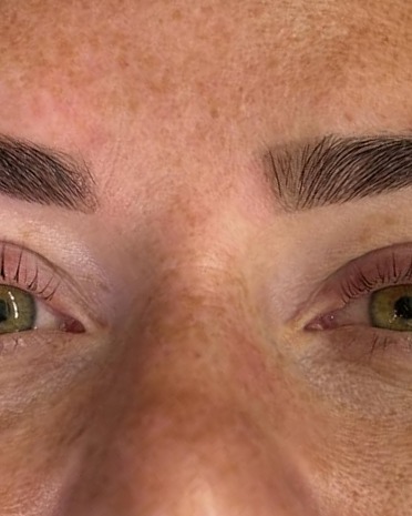 Gelifte wimpers en een gekamde wenkbrauw, groen oog